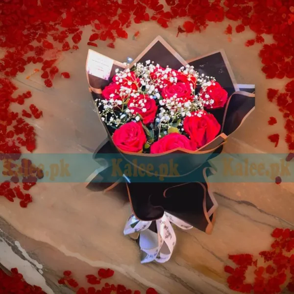 Elegant baby's breath bouquet with red roses, wrapped in soft paper and tied with a satin ribbon.