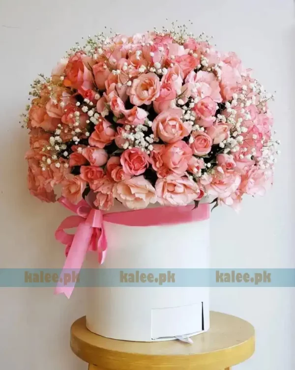 Pink flowers arranged in a box with baby's breath