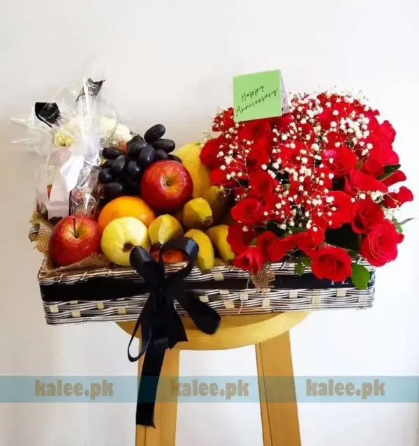 Fruit basket adorned with a red rose and baby's breath