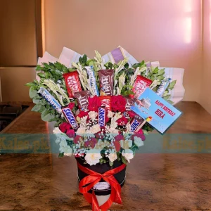 A box with white and red roses, baby's breath, and chocolates.