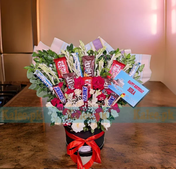 A box with white and red roses, baby's breath, and chocolates.