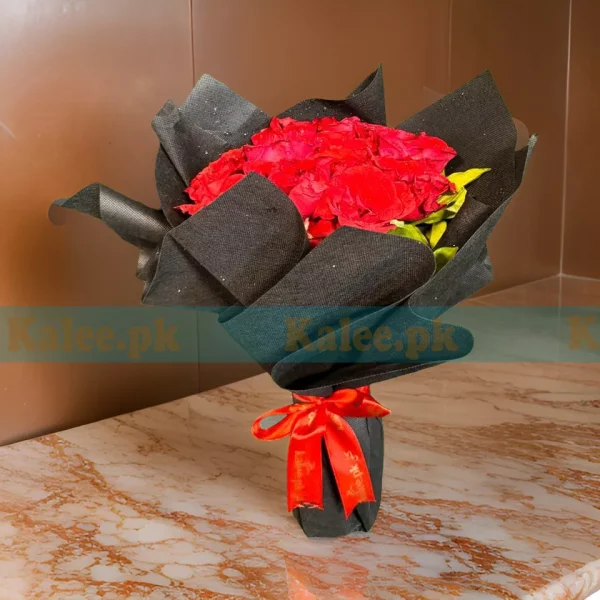 A bouquet of red roses wrapped in glossy black paper