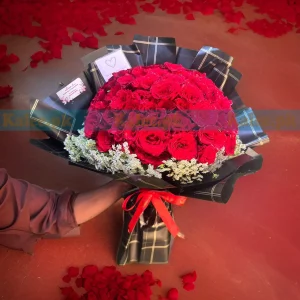 A magnificent 100 Red Rose Flower Bouquet, elegantly wrapped with delicate lacy lace for a luxurious floral arrangement.