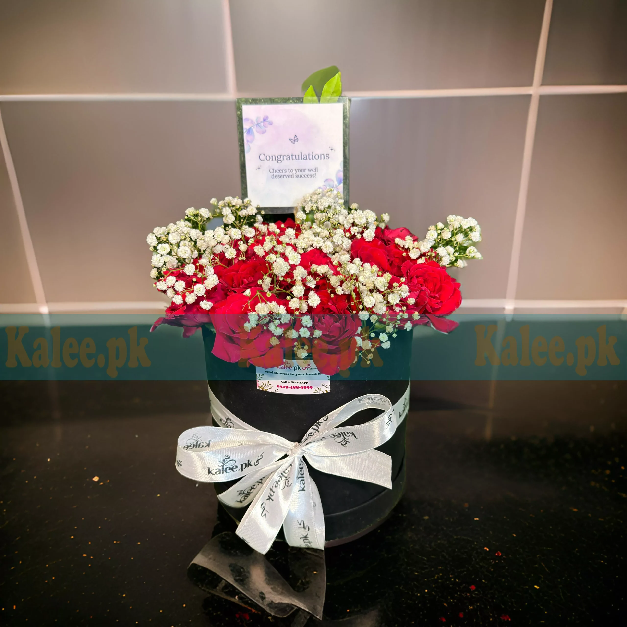 A box with red roses and baby's breath.