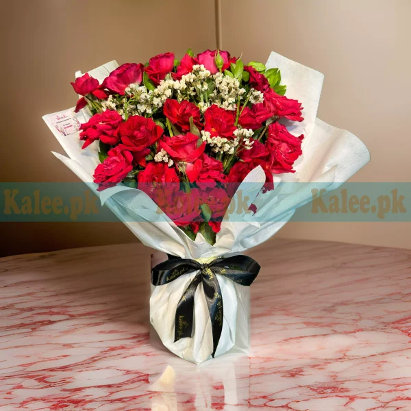 A stunning bouquet of red roses and statice.