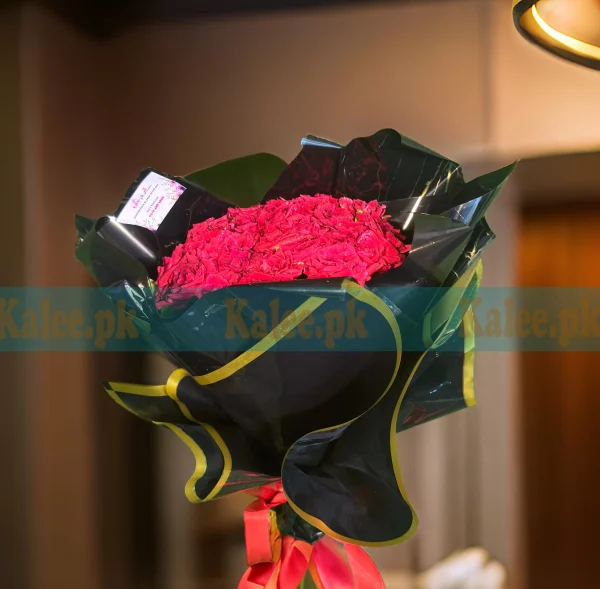 A bouquet of red roses wrapped in black paper.