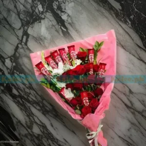 A bouquet featuring decadent chocolates surrounded by vibrant red rose flowers