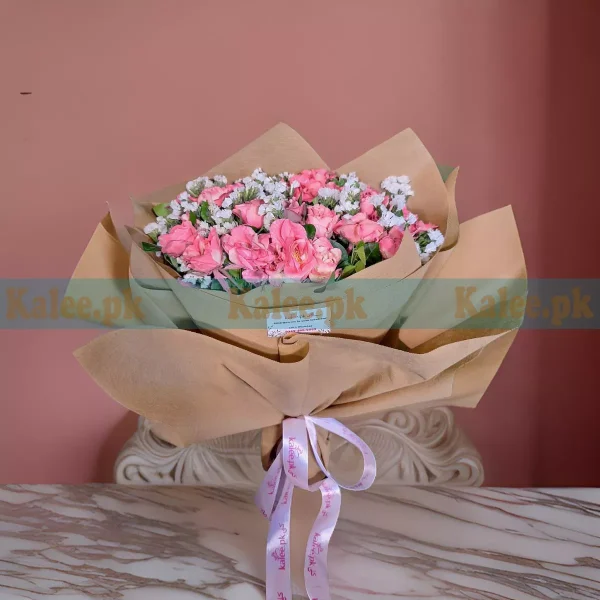 A bouquet with pink roses and statice.