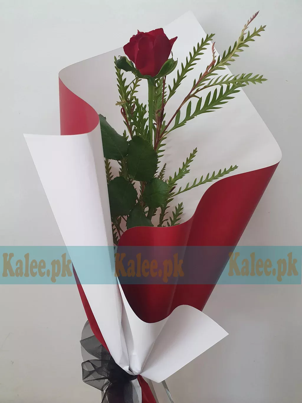 A single red rose elegantly wrapped in classy packaging.