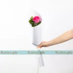 A single pink rose elegantly wrapped in lavish packaging.