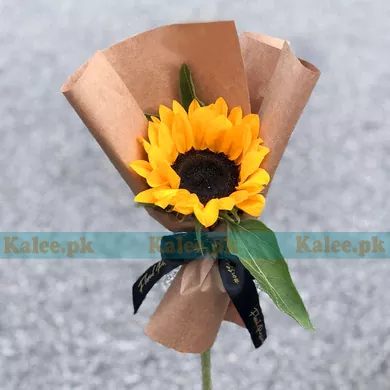 A single sunflower creatively wrapped with artisanal flair.