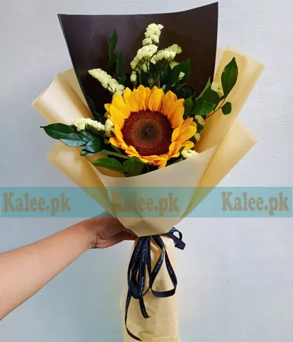 A single sunflower delicately wrapped in elegant paper.