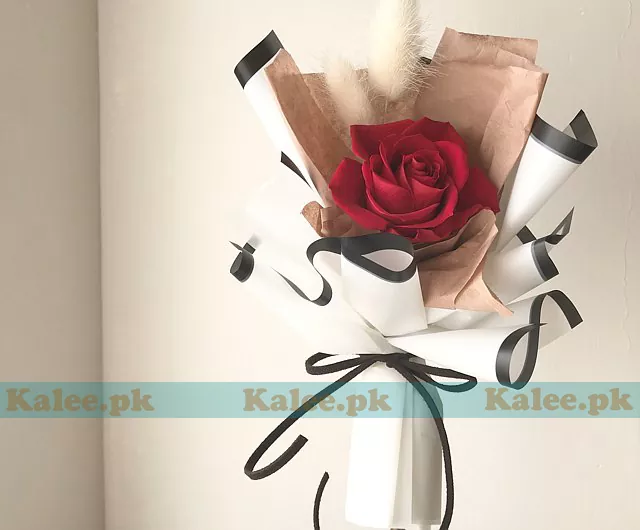 A single red rose presented in stylish wrapping.