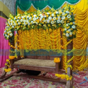 Stage adorned with glades, marigold, and white flowers