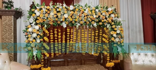 Stage adorned with glades, marigold, and red roses decoration