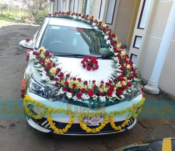 Car decorated with glades, red roses, and marigold flowers.