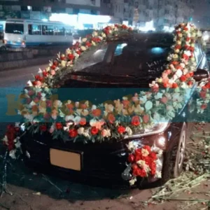 Car adorned with pink and red roses along with glades decoration.