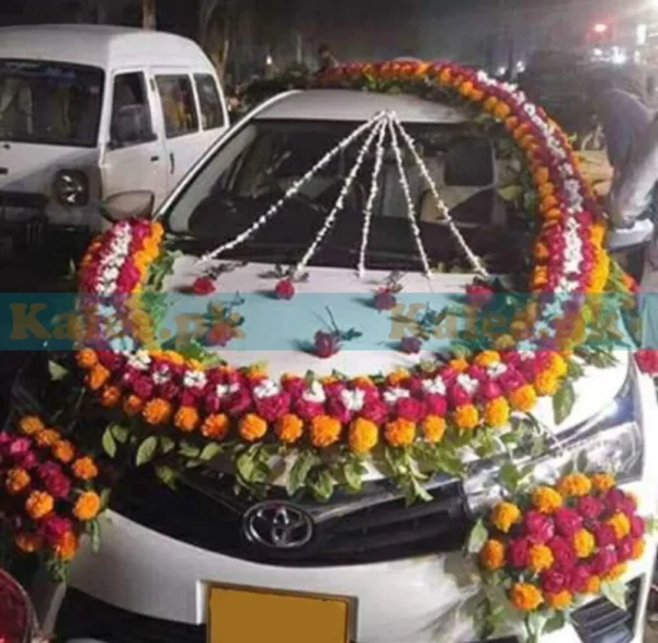 Car adorned with red roses, marigold, and glades decoration.