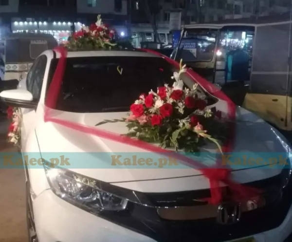 A car beautifully adorned with red roses, white glades, and tuberose flowers.
