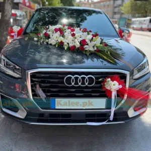 A wedding car elegantly adorned with red and white roses.