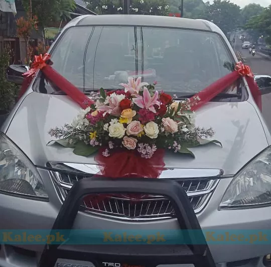 Wedding car adorned with pink lilies and mixed roses decoration.