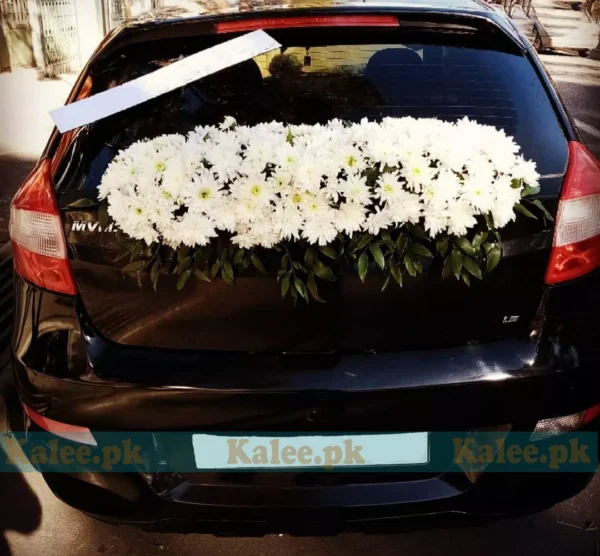 A car creatively adorned with white daisy flowers.