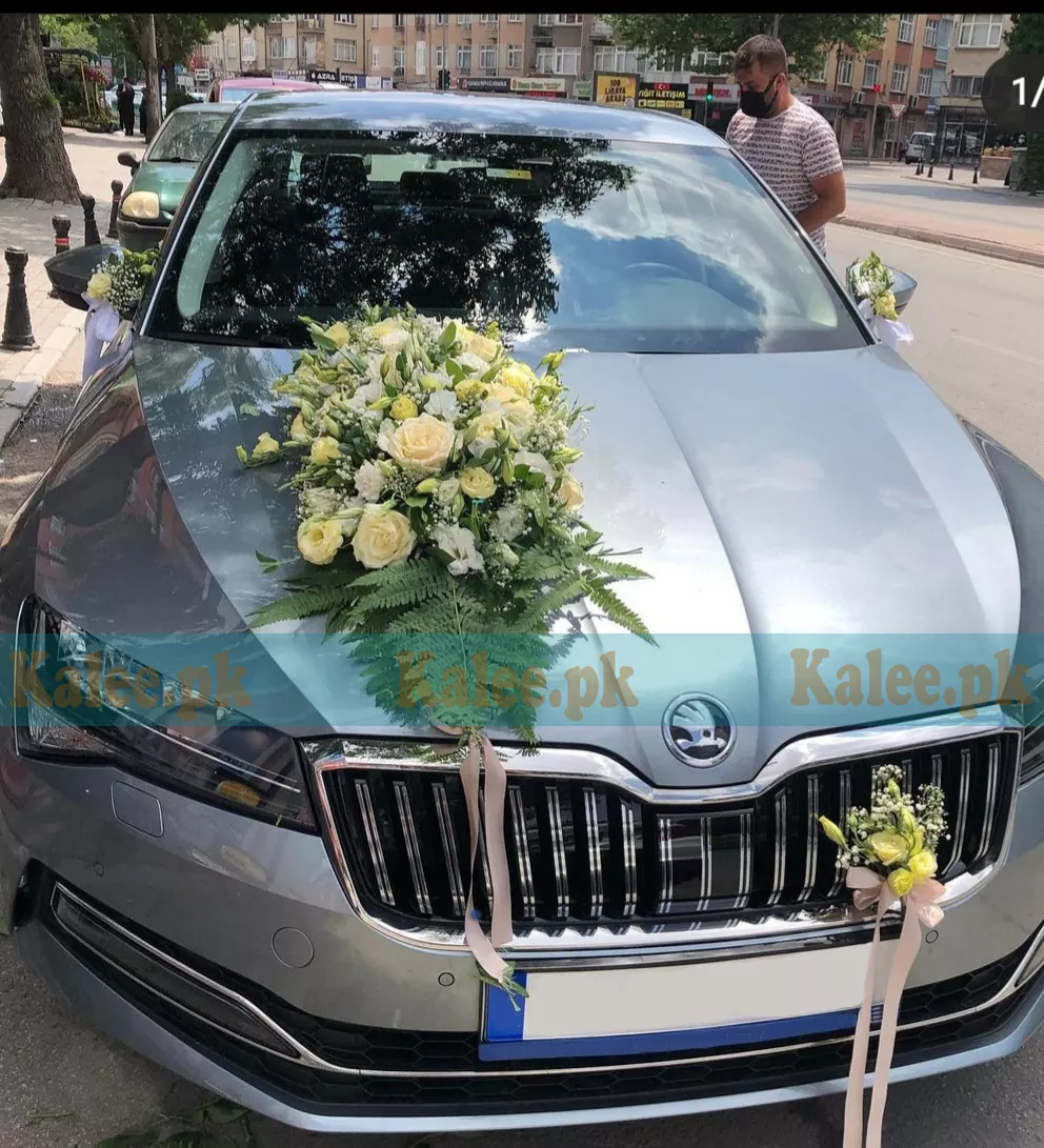 A luxurious car adorned with creamy white roses and glades.