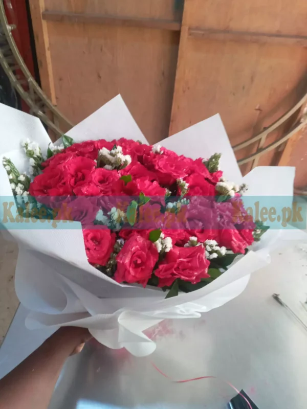 Bouquet of daisies and red-pink roses with chocolates, candle, and baby breath flowers