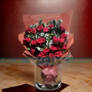 A bouquet of statice flowers and English red roses elegantly wrapped in fancy paper