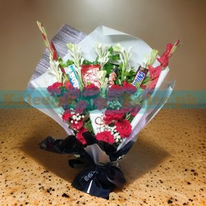 A delightful Chocolates Bouquet, featuring KitKat, Bounty, Snickers, and Mars bars, beautifully arranged with roses, glades, tuberose, and baby’s breath flowers.