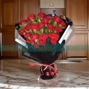 A bouquet featuring stunning red English roses elegantly wrapped in black paper