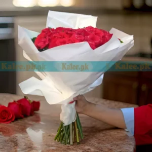 A bouquet of English red roses elegantly wrapped in fancy white paper