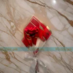 A serene crochet bouquet of red roses, meticulously handcrafted, offering a calming floral arrangement