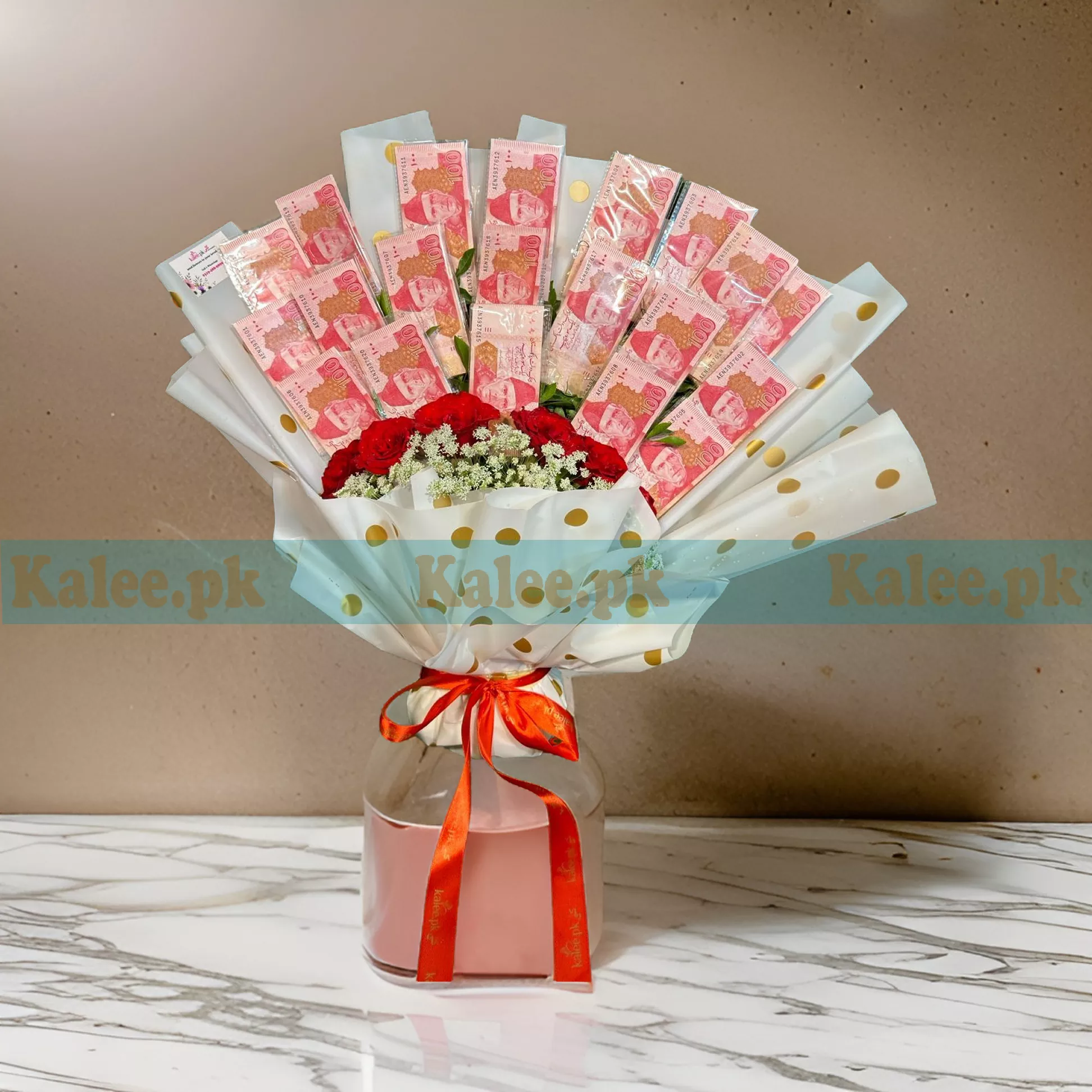 A Currency Bouquet with Flowers combining 100 rupee notes and decorative flowers.