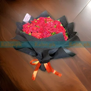 A red rose bouquet wrapped in black.