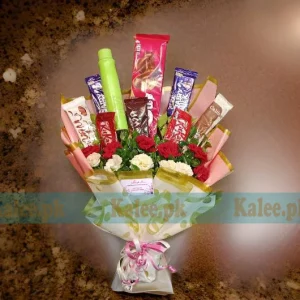 A bouquet with chocolates and white and red roses.