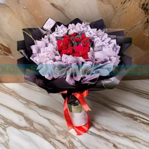 A fancy bouquet with cash notes and artificial red roses.