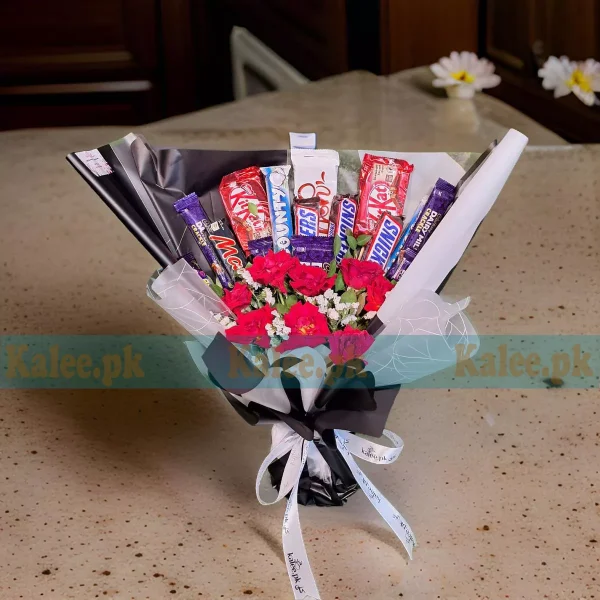 A bouquet with statice, red roses, and mixed chocolates.