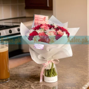 A bouquet of red and pink roses with white daisies.