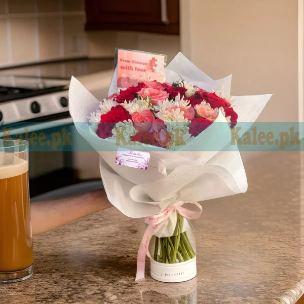 A bouquet of red and pink roses with white daisies.