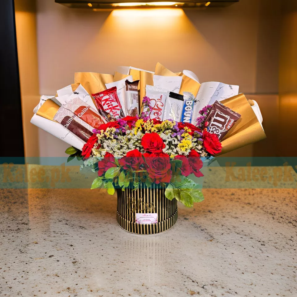 A box containing mixed colorful flowers and chocolates.