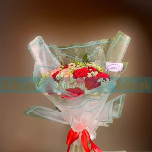 A bouquet of red and pink roses with delicate lacy lace flowers.