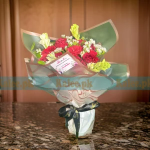 A bouquet of statice, tuberose, and red roses.