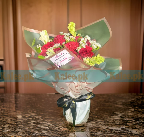 A bouquet of statice, tuberose, and red roses.