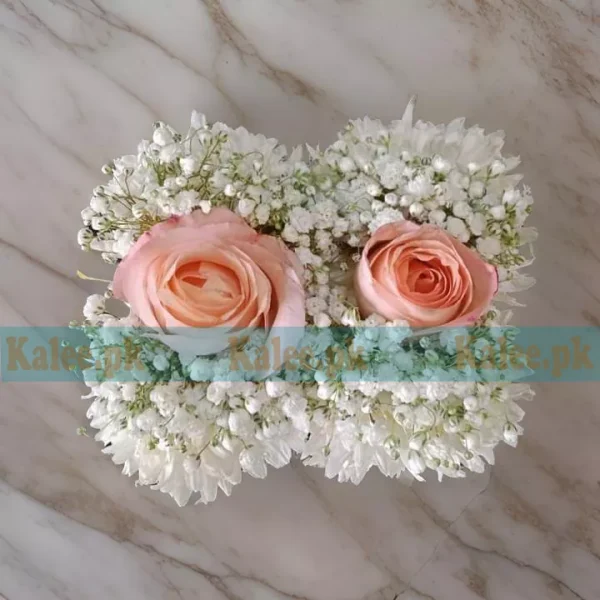 A pink rose gajra with star jasmine and baby's breath flowers.