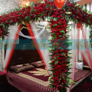 Bridal bedroom decoration with fresh red rose flowers for a romantic and luxurious wedding night setting.