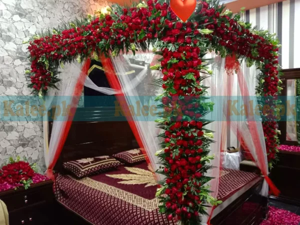 Bridal bedroom decoration with fresh red rose flowers for a romantic and luxurious wedding night setting.